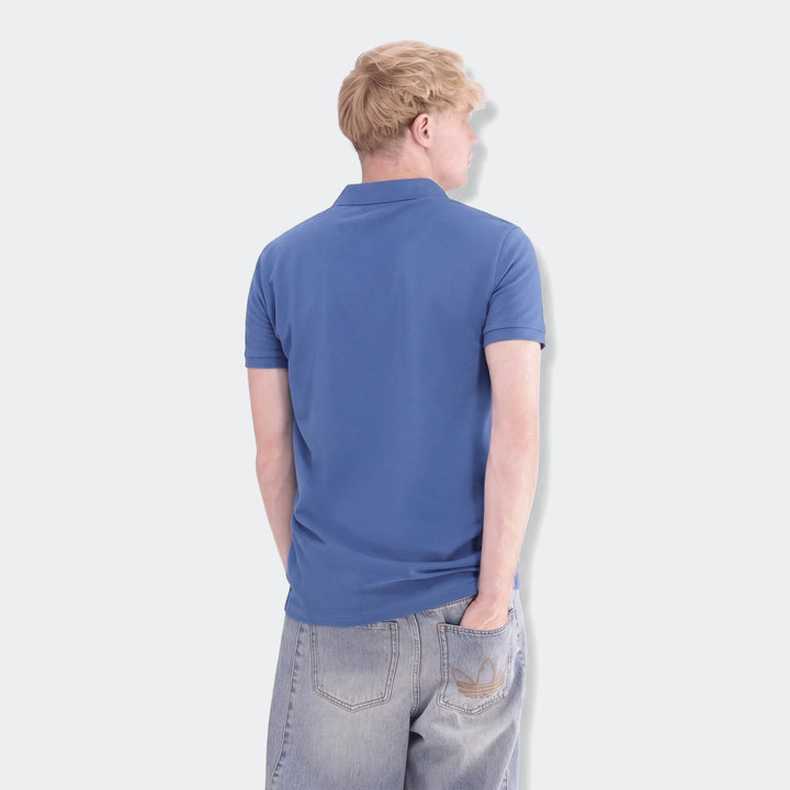 Blue Sportswear Slim Pique Polo Shirt on a male model from the back, paired with light wash jeans featuring an embroidered
