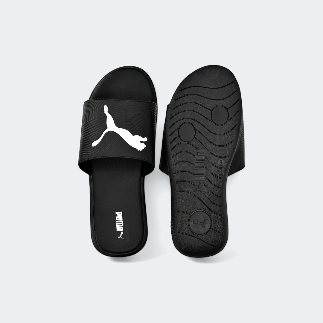A pair of black Puma Sporty Embossed 2.0 slides, one facing up with the white logo and the other showing the textured sole.