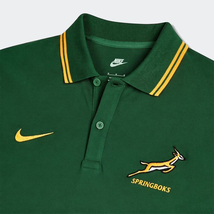 Close-up of a dark green Nike Springboks pique polo shirt, featuring embroidered Nike swoosh and Springbok logo, with a