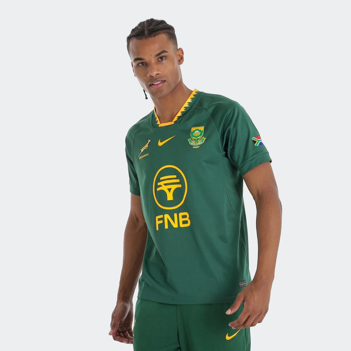 Male model wearing a green Spr Ynk Stdm Ss Jsy Hm Green Jersey, featuring multiple logos including FNB and Springboks, front