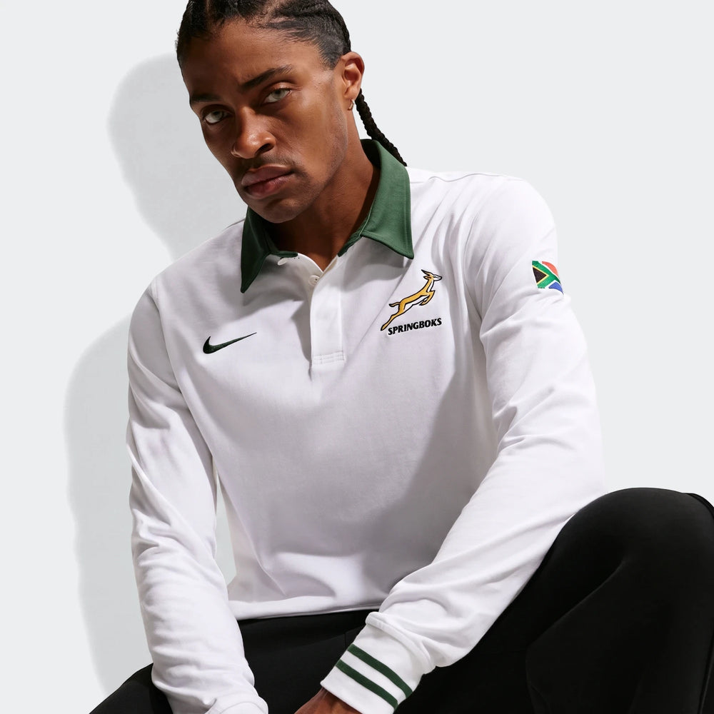 Man wearing a white Springboks Away Mens Nike Long Sleeve Rugby Jersey, featuring a green collar, Springboks logo, and South