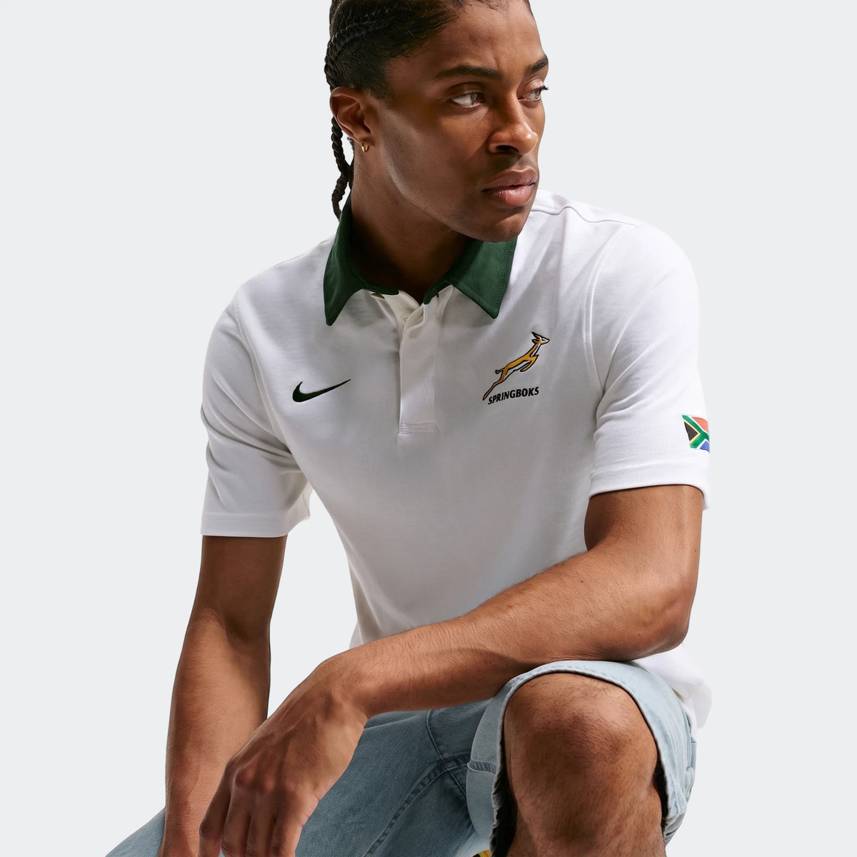 Man wearing a white Springboks Away Men's Nike Rugby Jersey with a dark green collar, Springboks logo, and South African