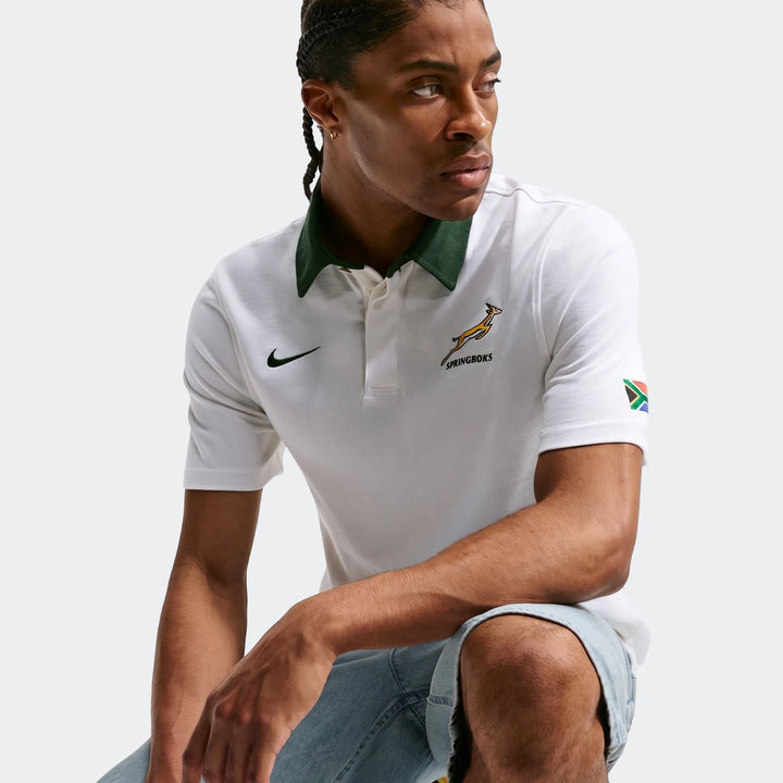 Man wearing a white Springboks Away Men's Nike Rugby Jersey with a dark green collar, Springboks logo, and South African