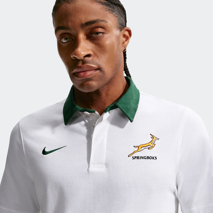 Close-up of a man wearing a white Springboks Away Nike Rugby Jersey with a green collar and team logo.