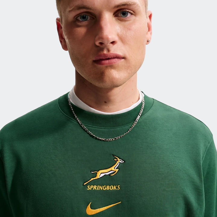 Close-up of a man wearing a dark green Springboks Men's French Terry Crew sweatshirt, featuring embroidered Springbok and