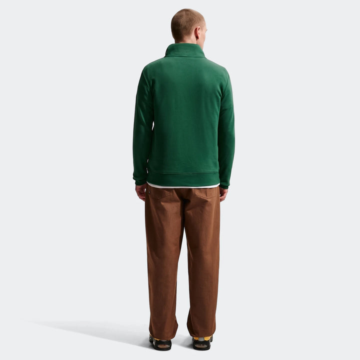 Men's green Nike 1/2 zip sweater from the Springboks collection, styled with brown pants and sandals, viewed from the back.