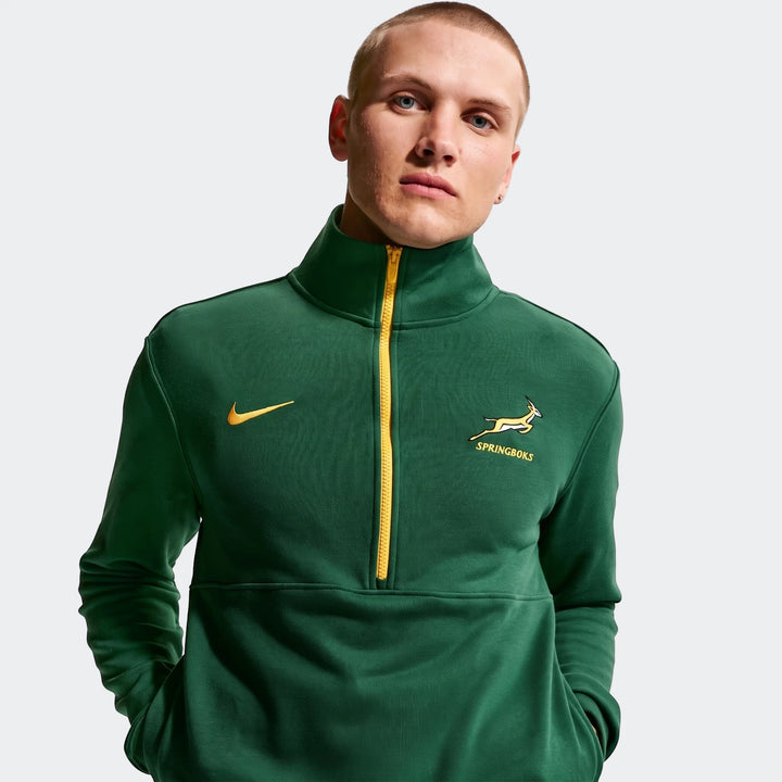 A male model in a green Springboks Men's Nike 1/2 zip sweater with yellow zipper and logos, posing on a plain background.