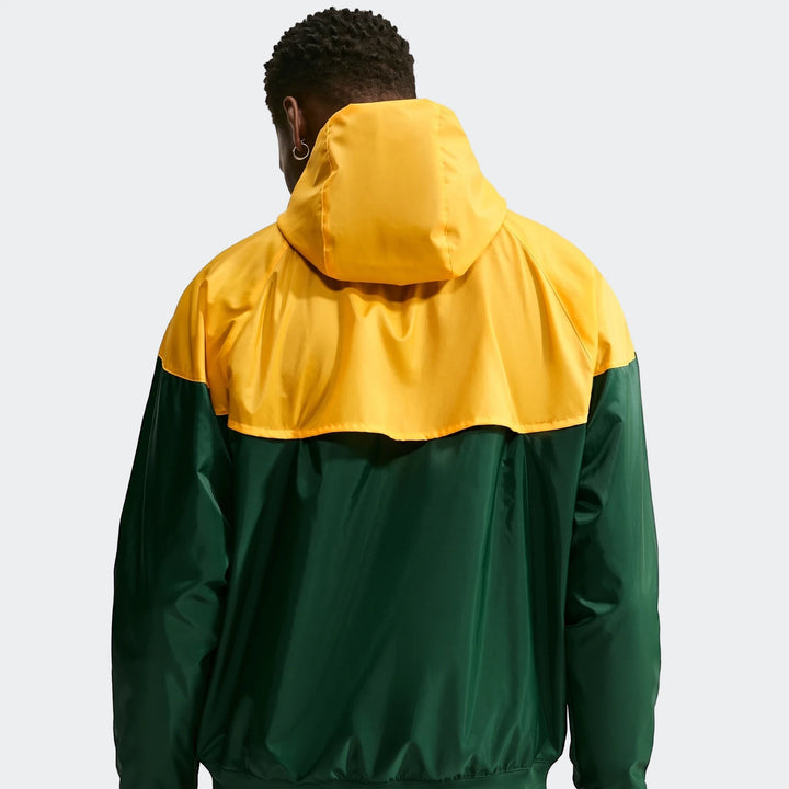 Rear view of a person wearing a Springboks Nike Windrunner jacket, featuring yellow and dark green color blocking and a hood.