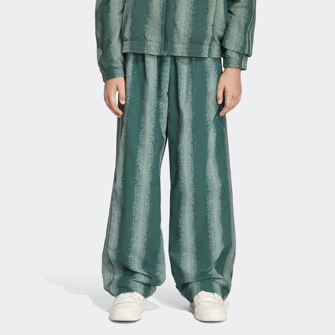 Green striped Sst Loose Track Pants with a wide-leg design, worn with matching track jacket and white sneakers, front view.