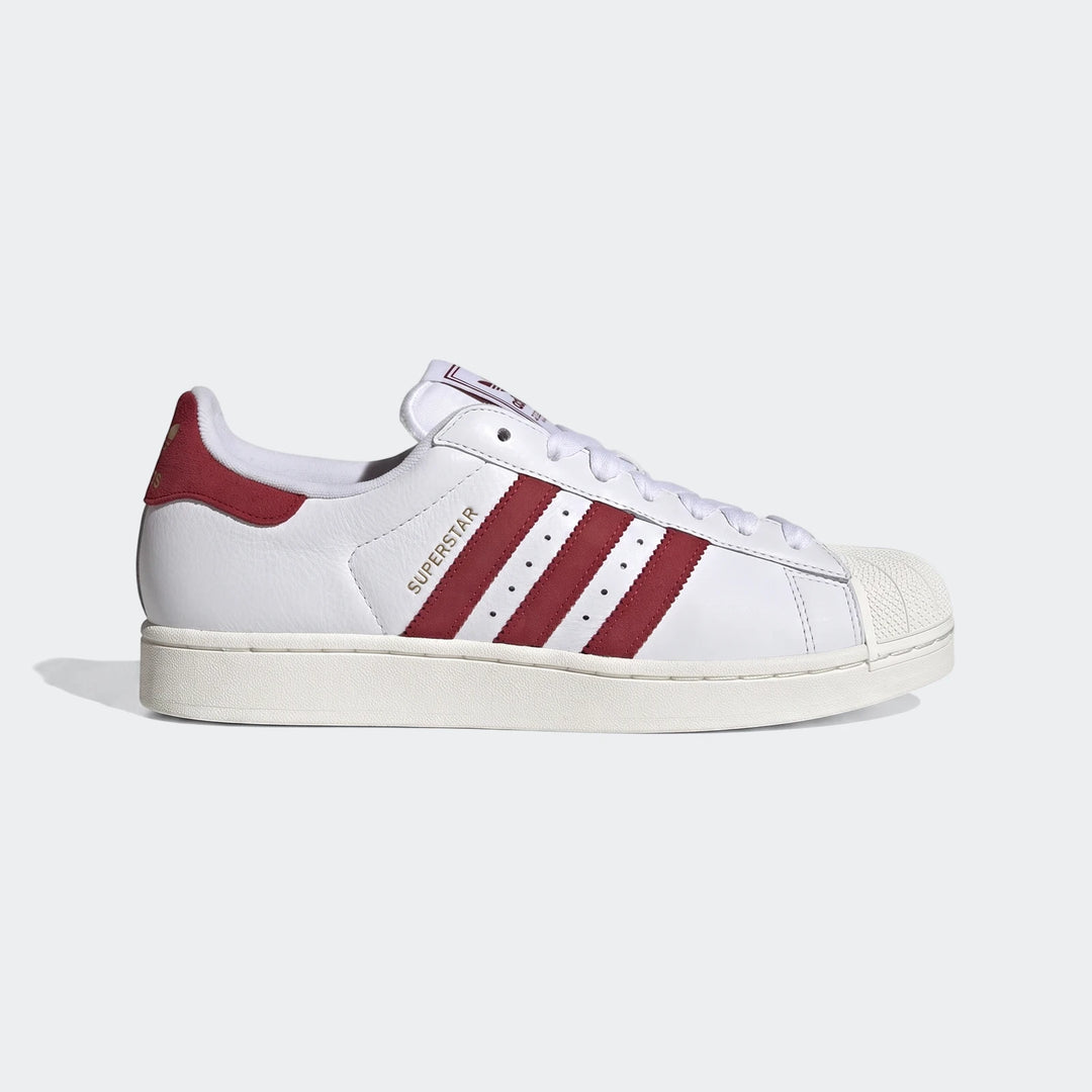 White Adidas Superstar II low-top sneakers with red stripes and shell toe, shown from a side view.