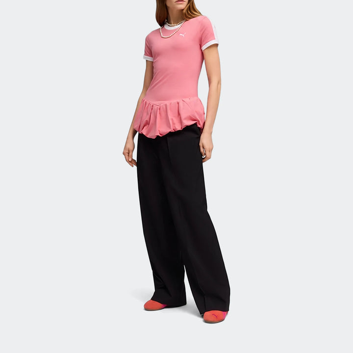 Pink Puma T7 Balloon Crew Neck Short Sleeve T-Shirt with ruffled hem, paired with black wide-leg pants and coral flats, worn