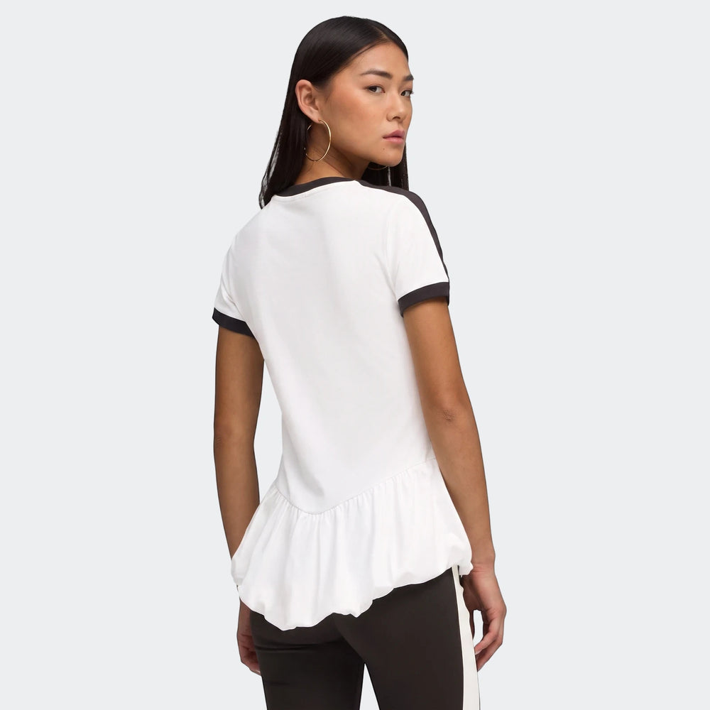 Woman facing away, looking over shoulder, wearing a white T7 Balloon Crew Neck Short Sleeve T-Shirt with black stripes and a