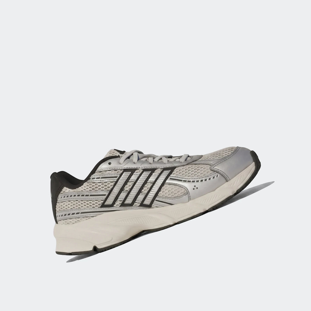 Silver and black Technochaos 2000 athletic shoe with mesh and synthetic overlays, viewed from the side-front on an angled