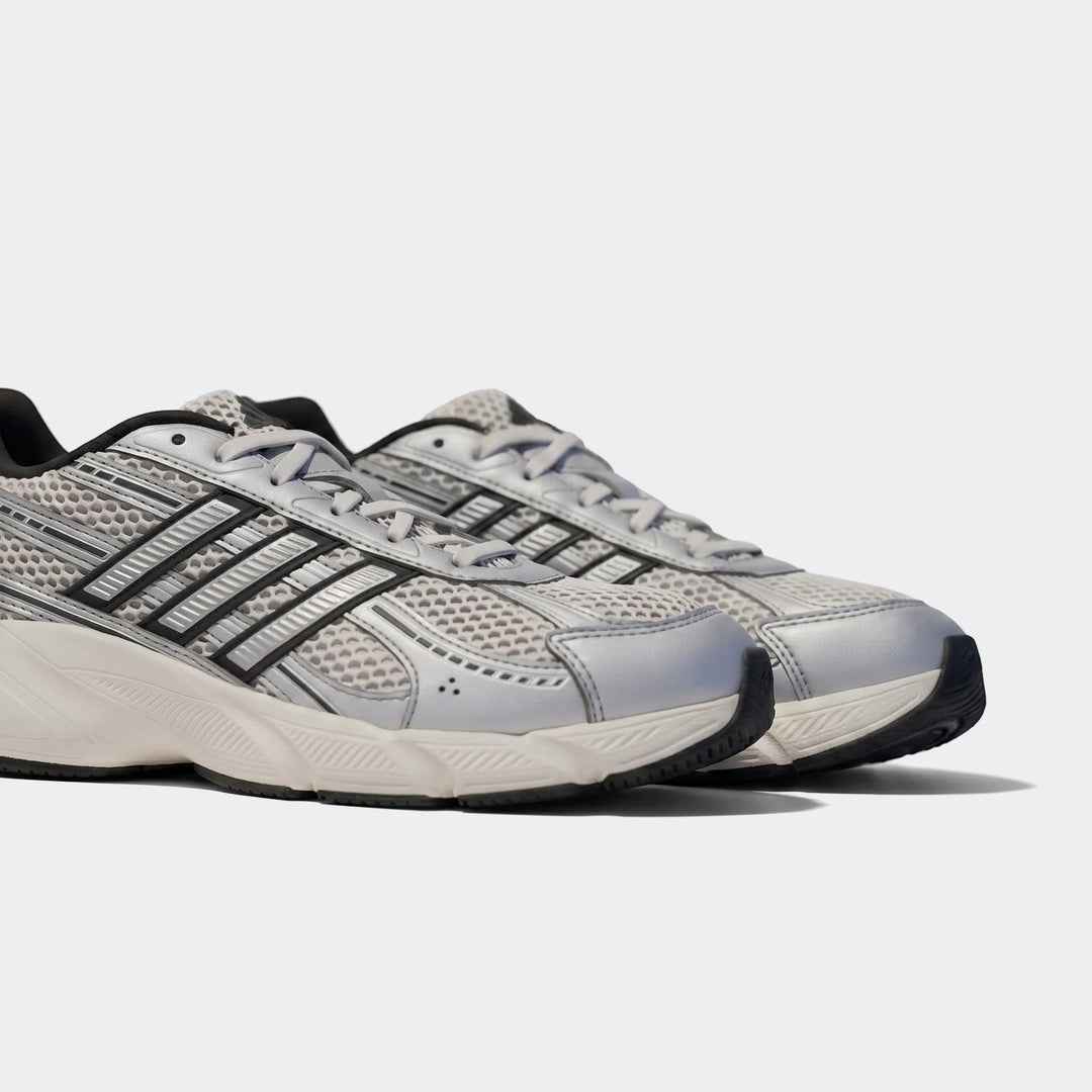 A pair of silver and black Technochaos 2000 athletic shoes with mesh and metallic details, viewed from a side angle.