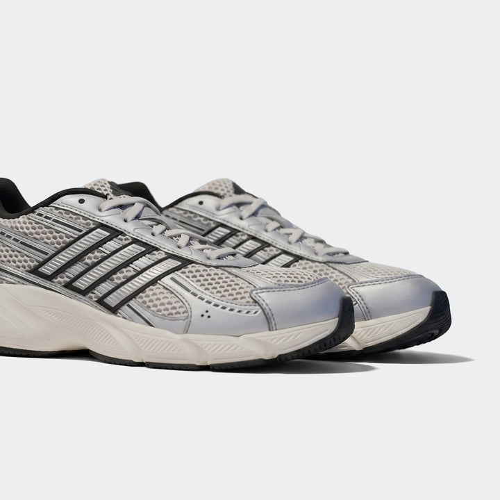 A pair of silver and black Technochaos 2000 athletic shoes with mesh and metallic details, viewed from a side angle.