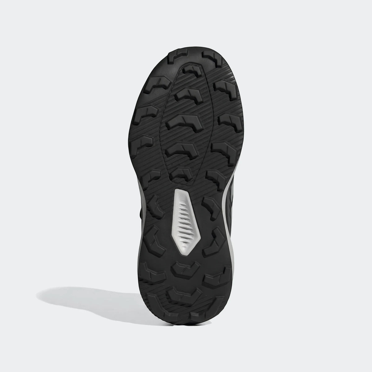 Black and white Terrex Tracefinder Cf C shoe sole with an aggressive textured tread pattern for enhanced grip.