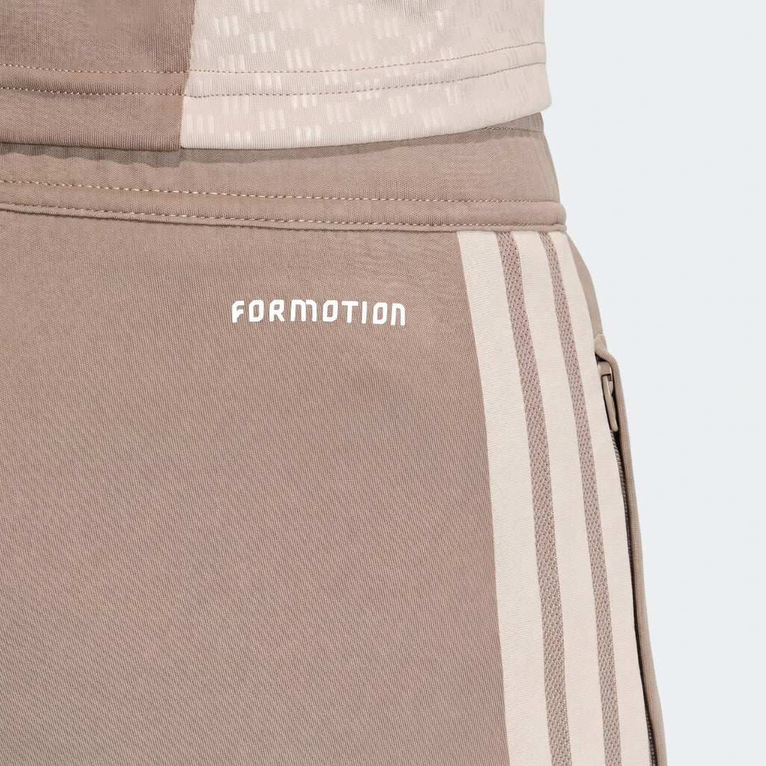 Close-up of Tior26C Pant brown athletic pants with a white Formotion logo and cream triple stripes on the side.