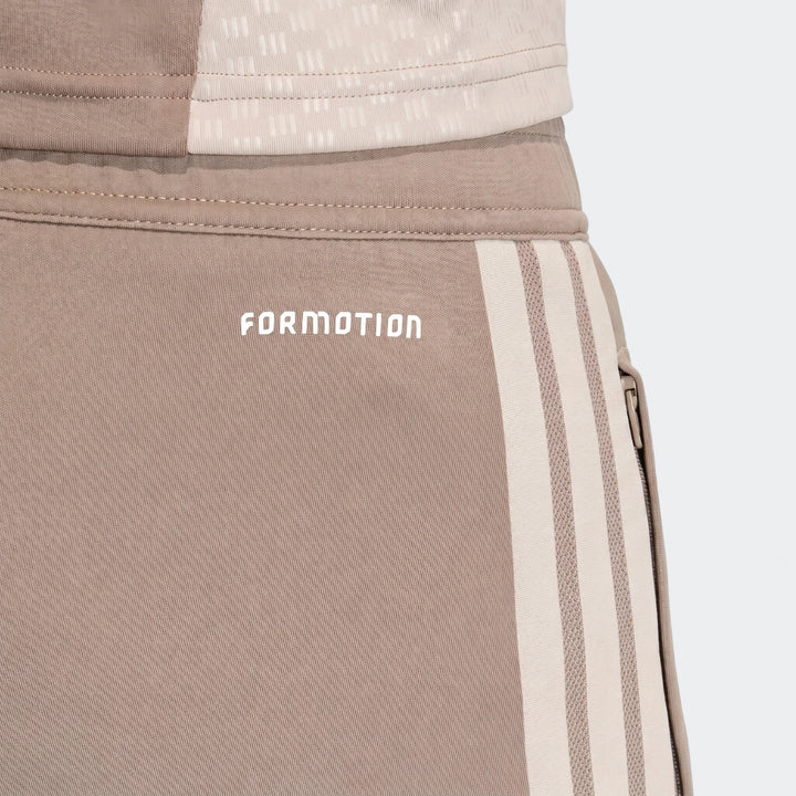 Close-up of Tior26C Pant brown athletic pants with a white Formotion logo and cream triple stripes on the side.