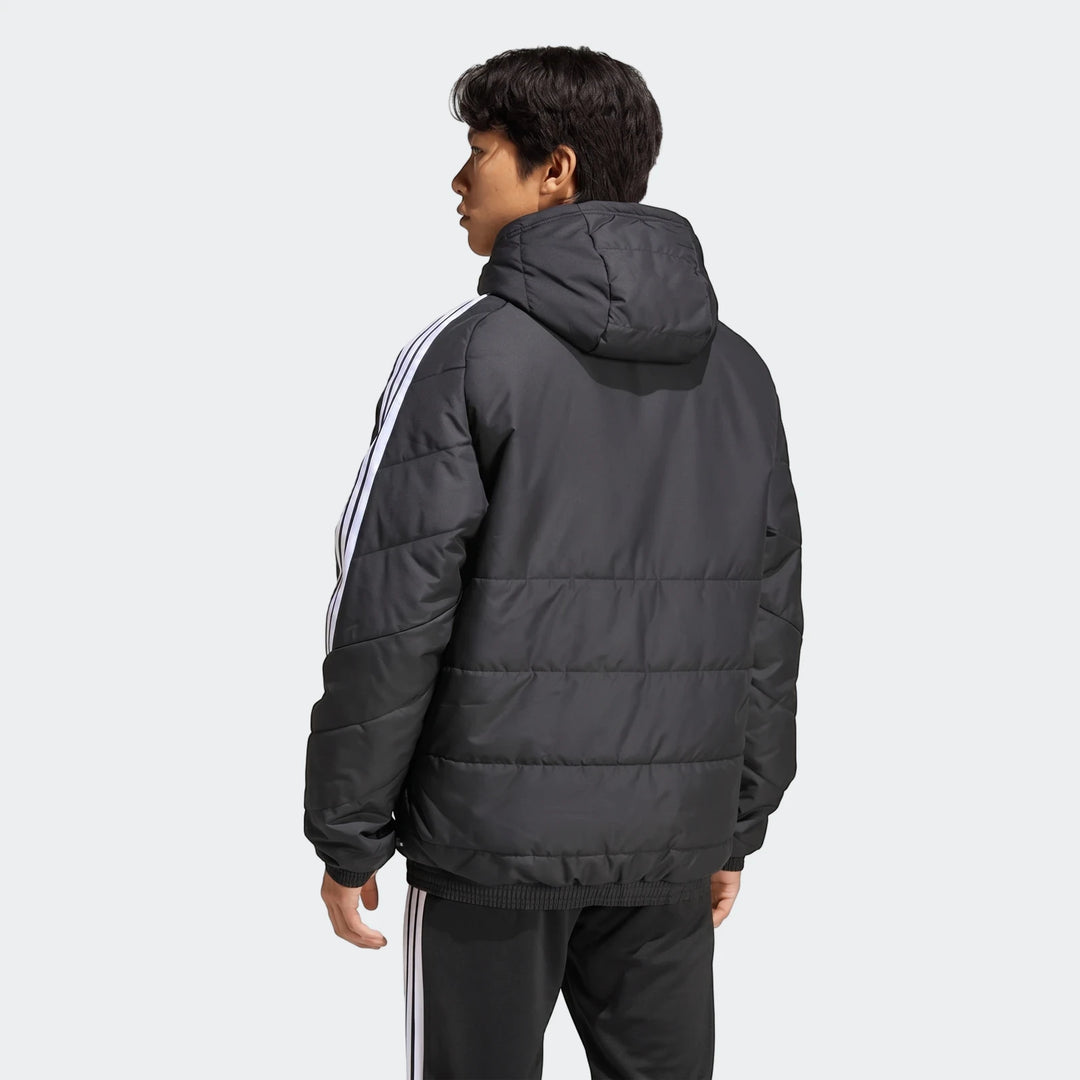 Rear view of a male model wearing a black Adidas Tiro 26 Windbreaker Jacket with white 3-Stripes on the sleeves, paired with