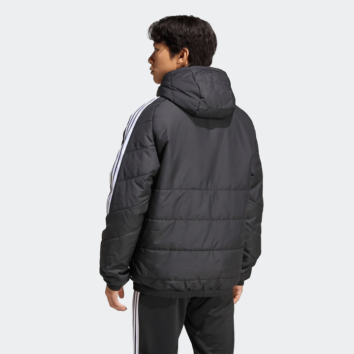 Rear view of a male model wearing a black Adidas Tiro 26 Windbreaker Jacket with white 3-Stripes on the sleeves, paired with
