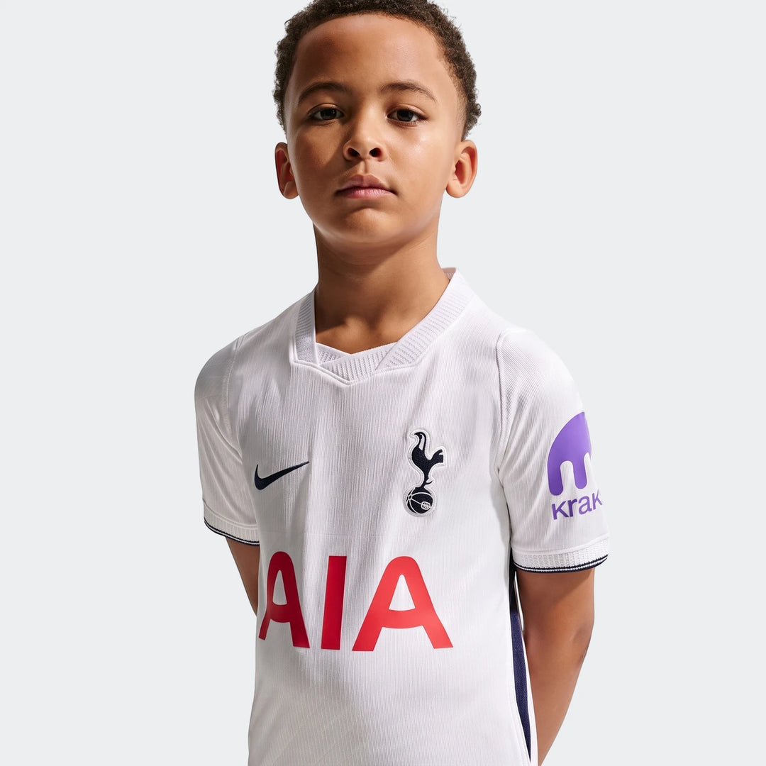 Boy wearing a white Tottenham Hotspur 2026/27 Stadium Home Nike Dri-Fit soccer replica jersey with team logos.