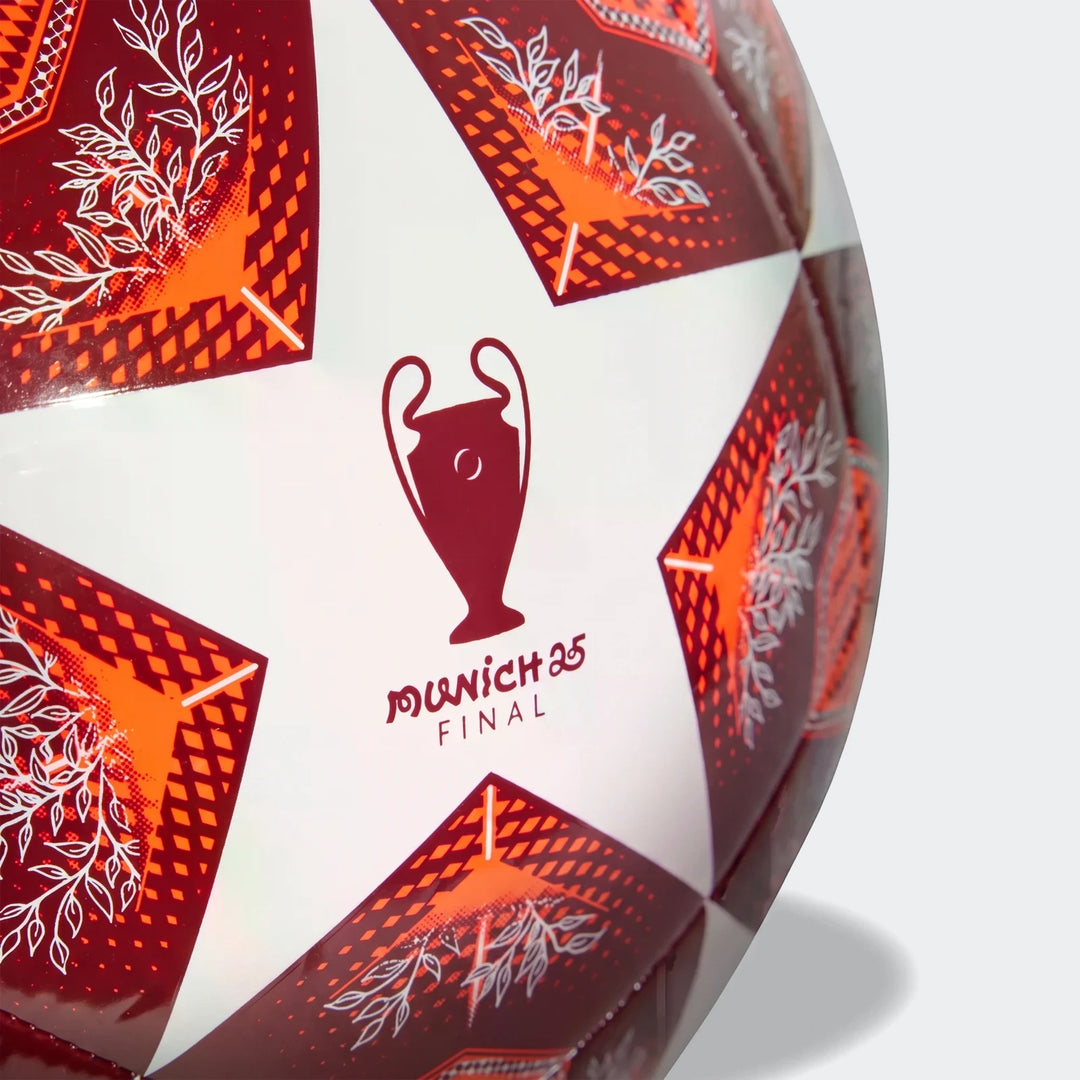Close-up of a Ucl Club size 4 white, red, and orange football with UEFA Champions League logo and 'Munich 25 Final' text.