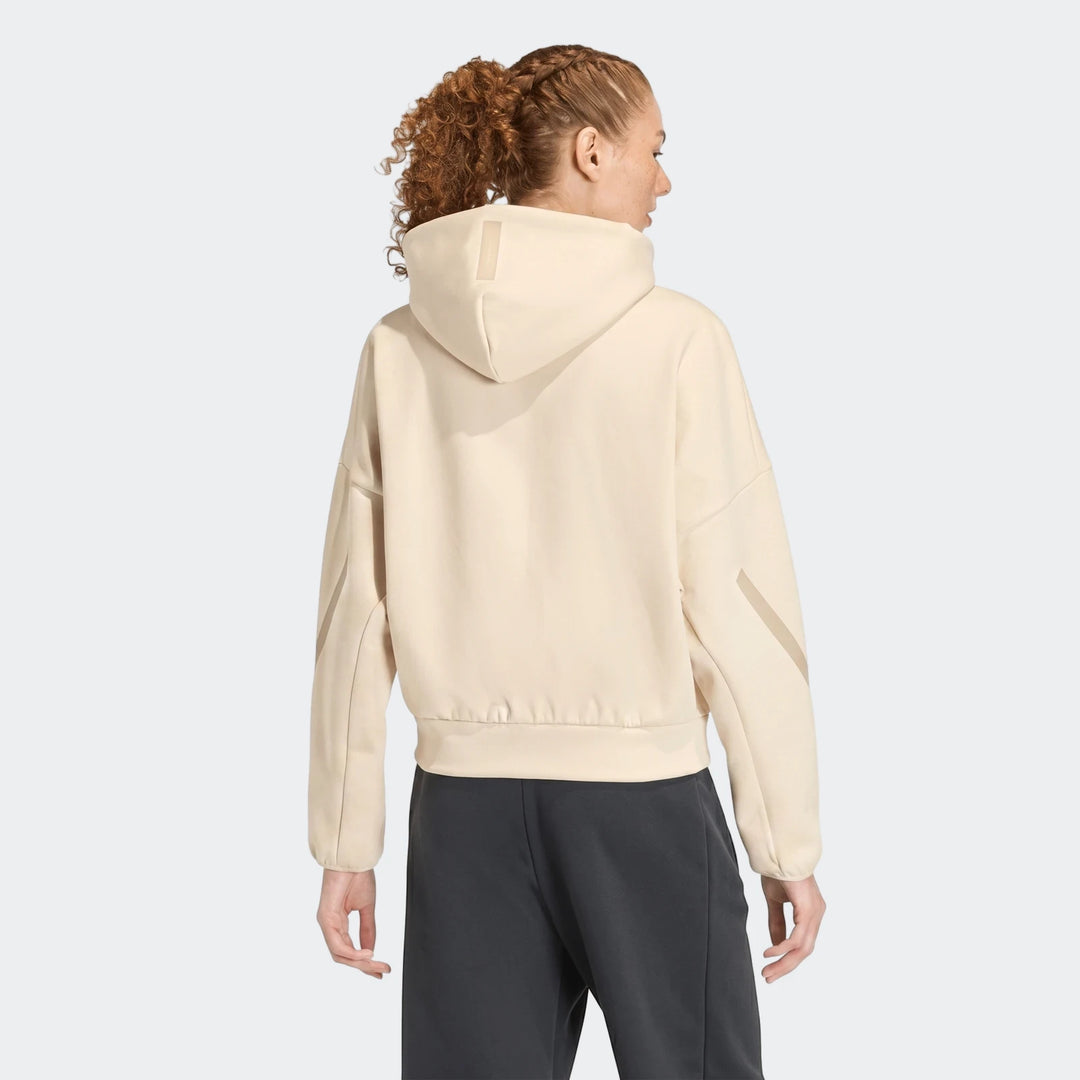 Rear view of a woman wearing a beige W Z.N.E Fz Jacket hoodie with dark pants, showcasing the design.