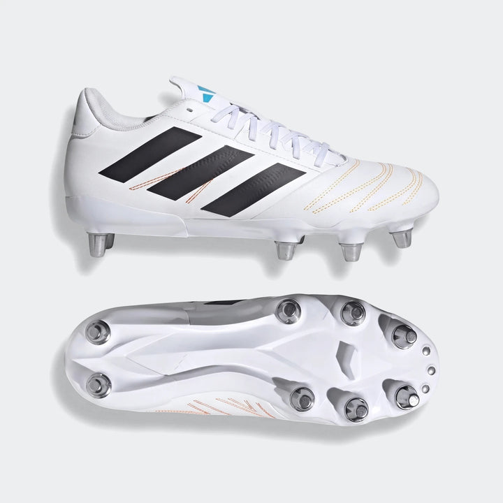 Pair of white Adidas Kakari Elite SG rugby boots with black stripes and orange stitching, shown from two angles.