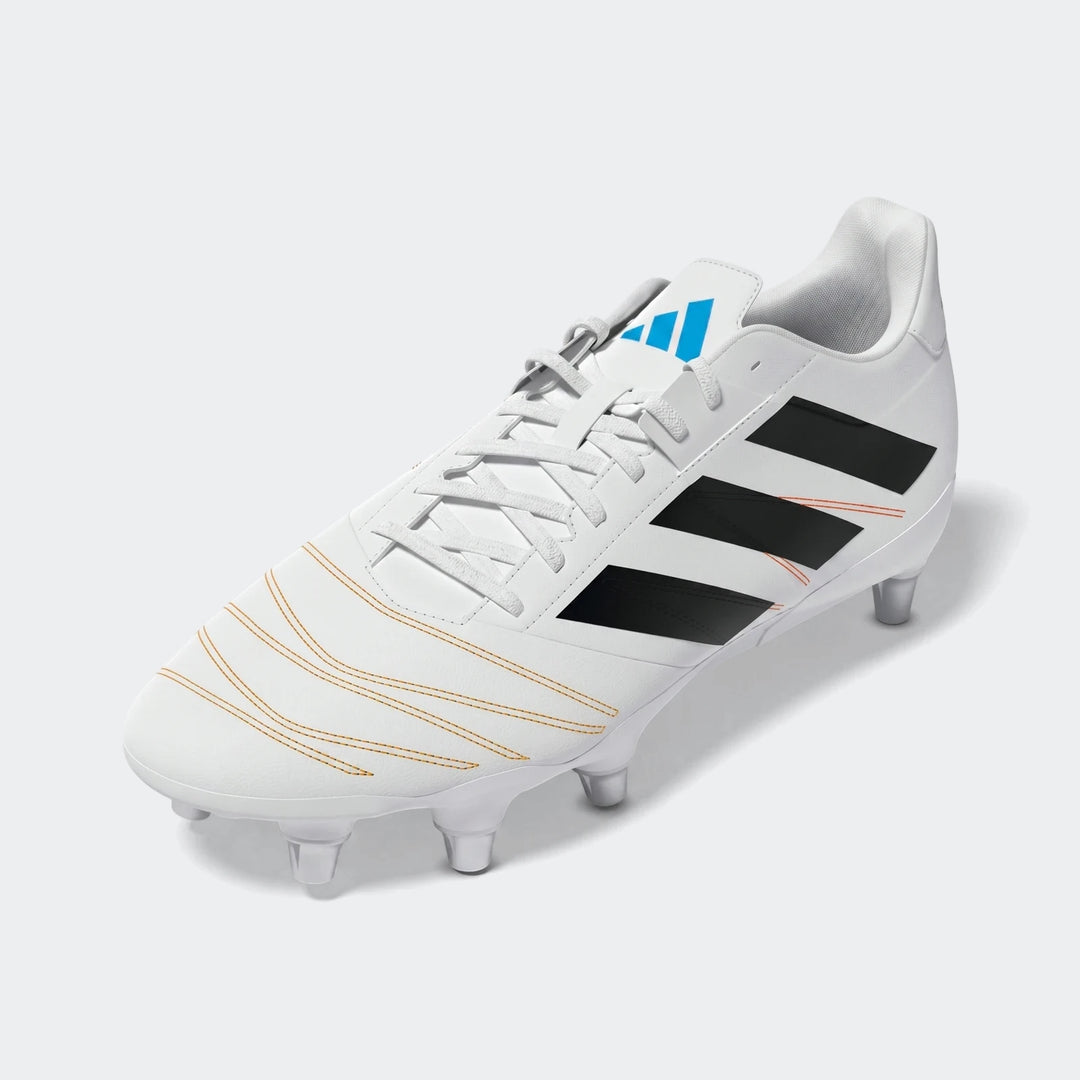 White Adidas Kakari Elite SG rugby boots with black three stripes, a blue logo, and orange stitching accents, shown at a