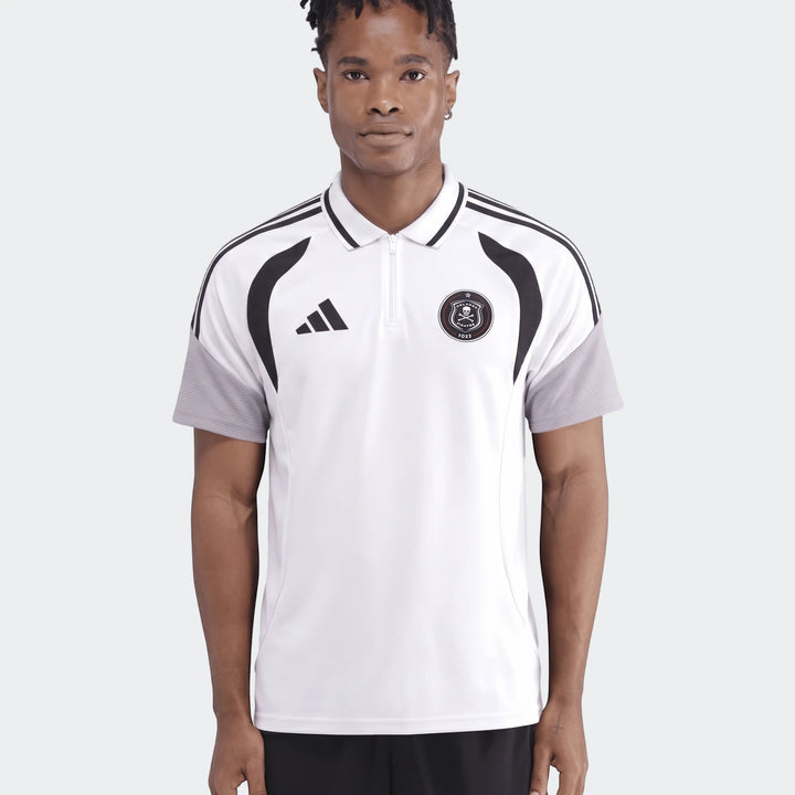 Male model wearing a white Adidas Op Tiro26C Polo shirt with black stripes and Orlando Pirates badge, front view.