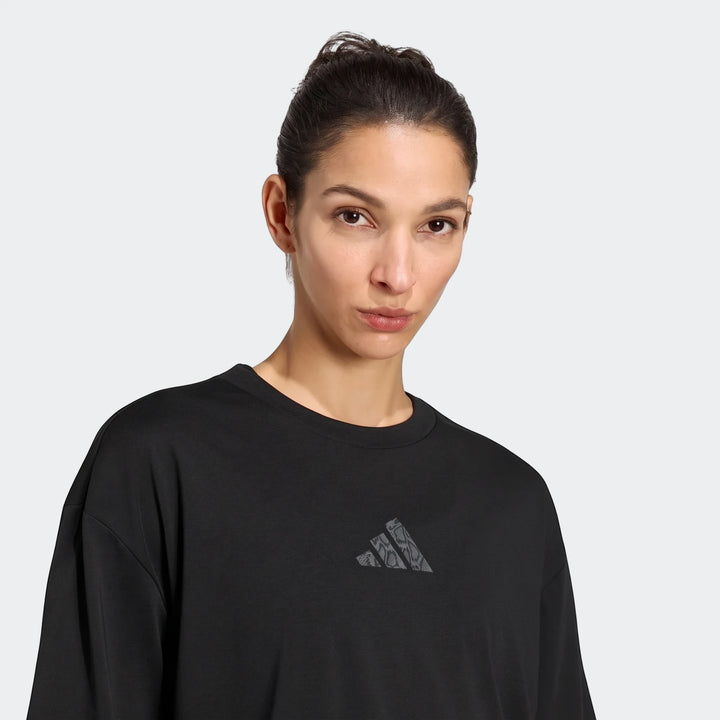 Woman wearing a black Adidas Climacool Animal Training Graphic T-Shirt with an animal print logo, shown in a close-up.