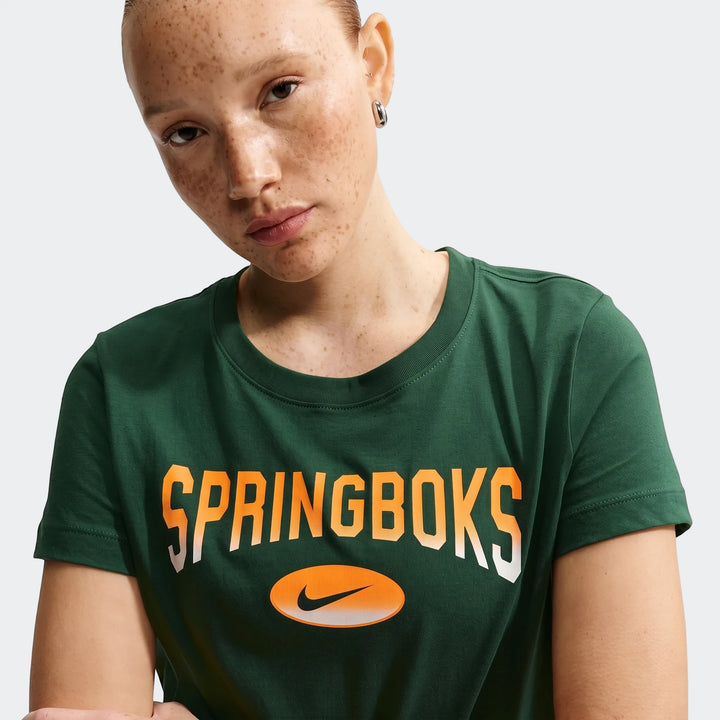 Woman wearing a dark green Nike South Africa Springboks Rugby T-shirt with orange and white lettering, close-up shot.