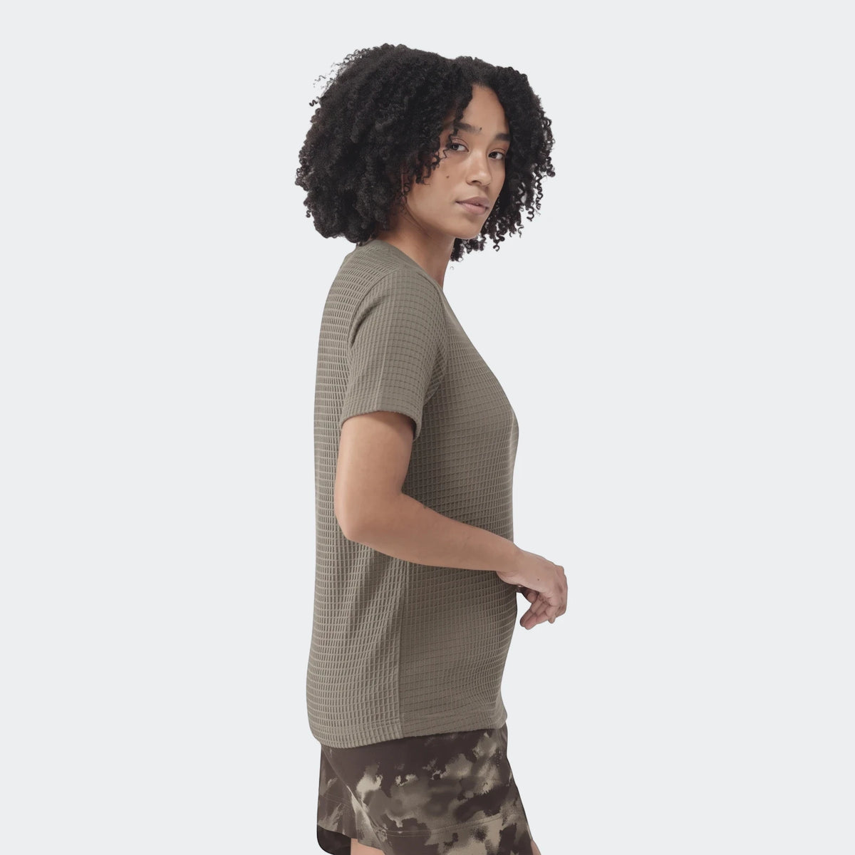 Olive green waffle knit essential t-shirt for women, featuring short sleeves and a textured fabric, shown from the side.
