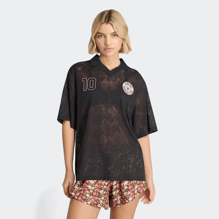 A model wears a black X Farm Rio Premium Jersey with a white '10' and a round logo, paired with floral shorts.