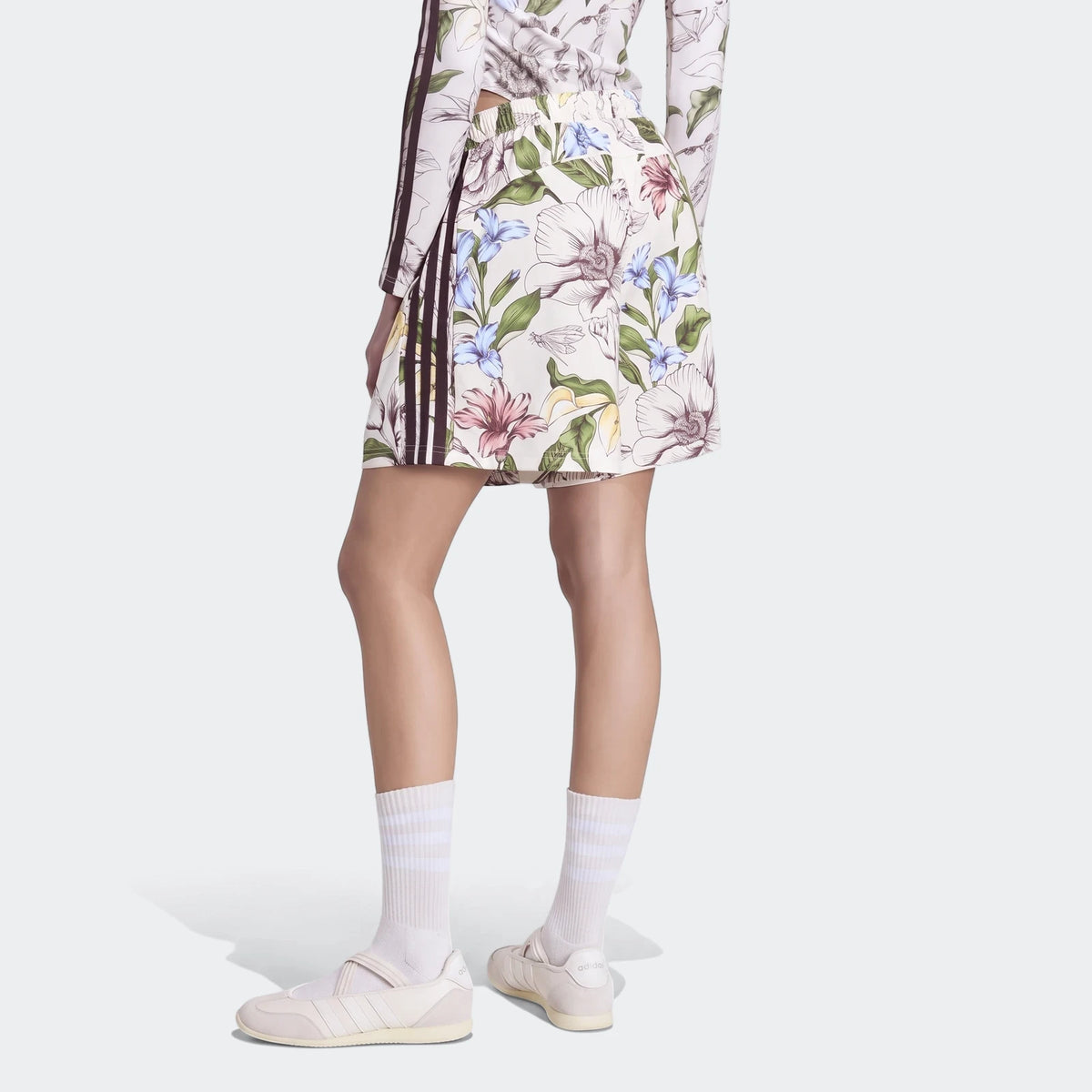 Model wearing white X Farm Rio Premium Shorts and matching top with a colorful floral print and brown stripes, paired with