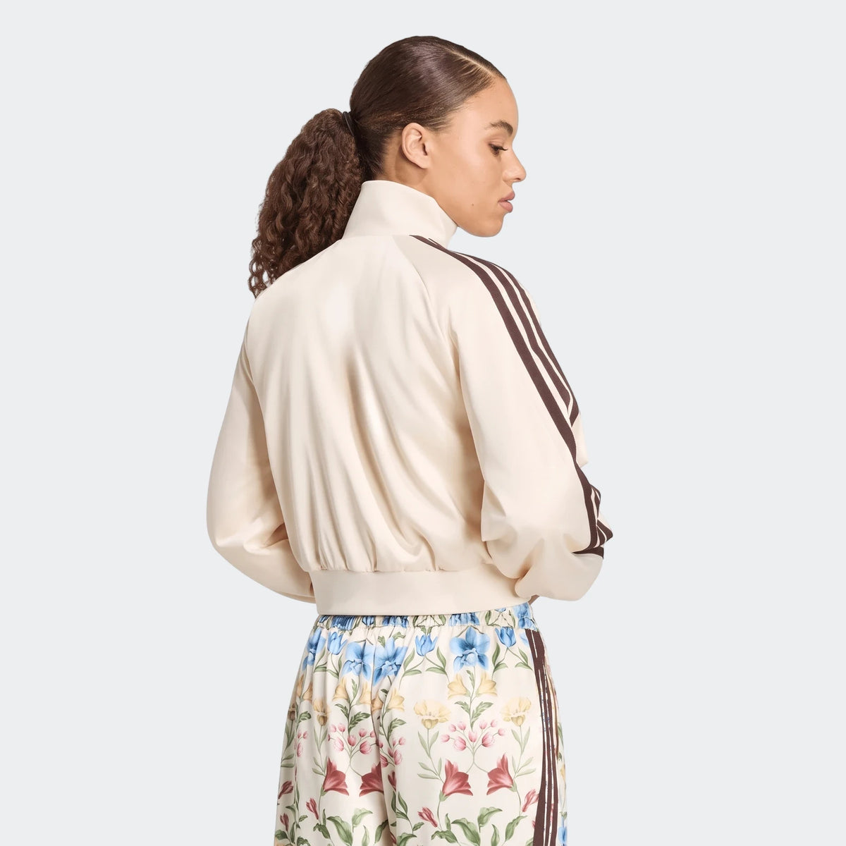Women's off-white X Farm Rio Premium Tracktop with dark brown three-stripes on sleeves, paired with floral print pants,