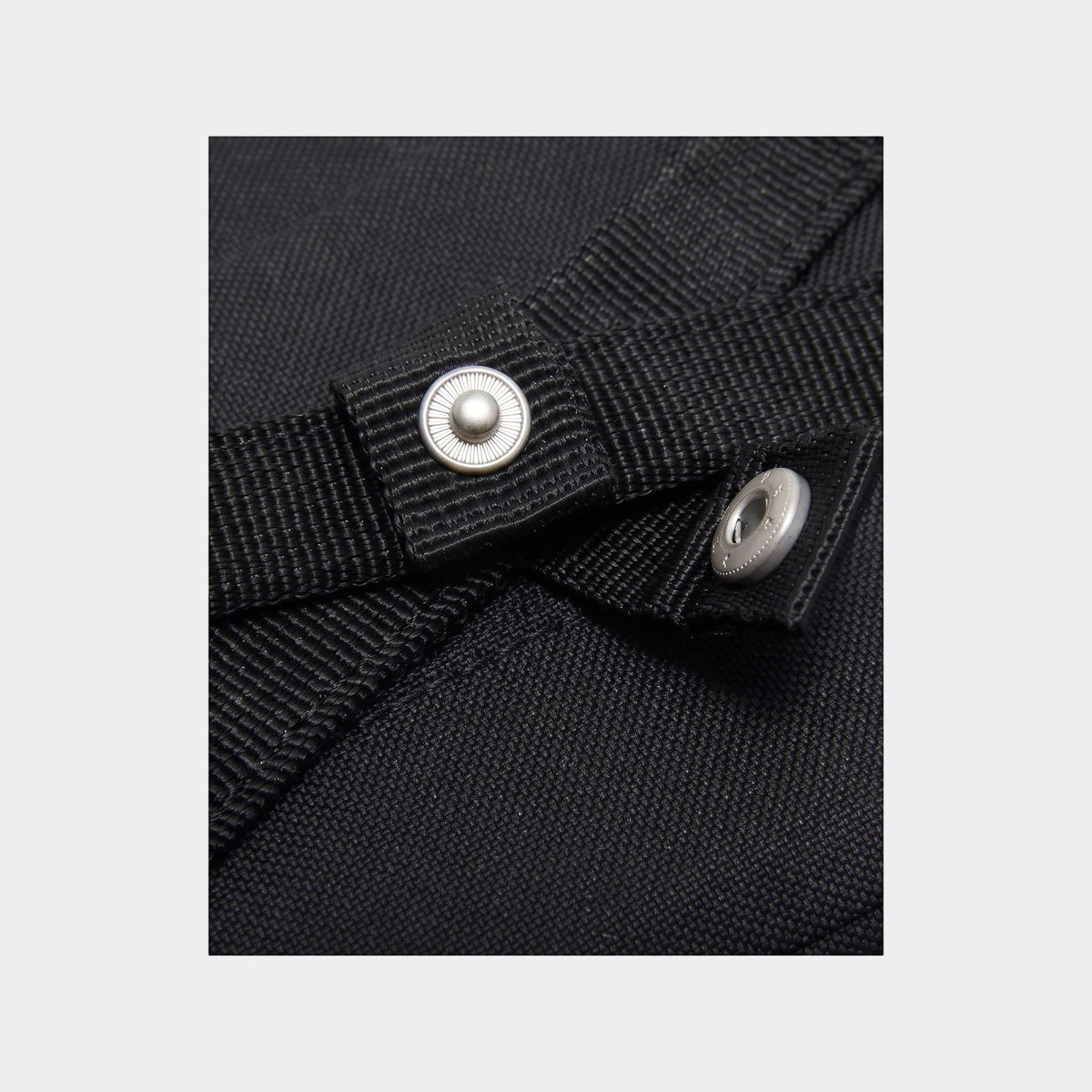 Close-up detail of a black Y Nk Gym Club Sp23 bag, showing the woven fabric and a silver snap button.