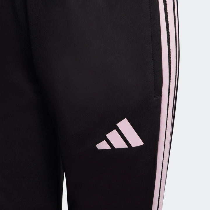 Close-up of Youth Adidas Tiro 26 Competition Training Pants in black with pink three-stripe detail and logo. Athleticwear.