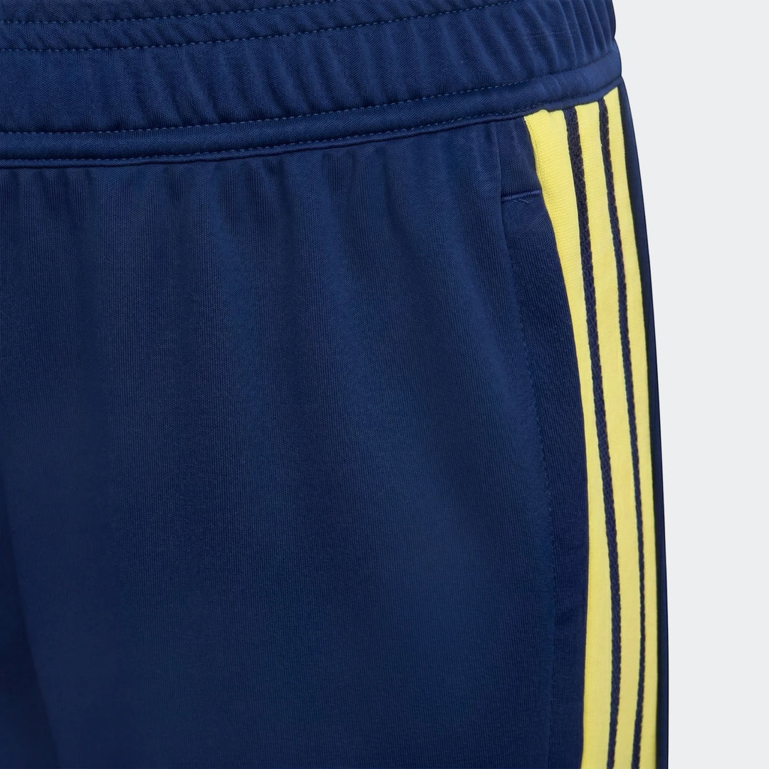 Youth Tiro 26 Competition Training Pants in dark blue, featuring three bright yellow stripes on the side, close-up detail.