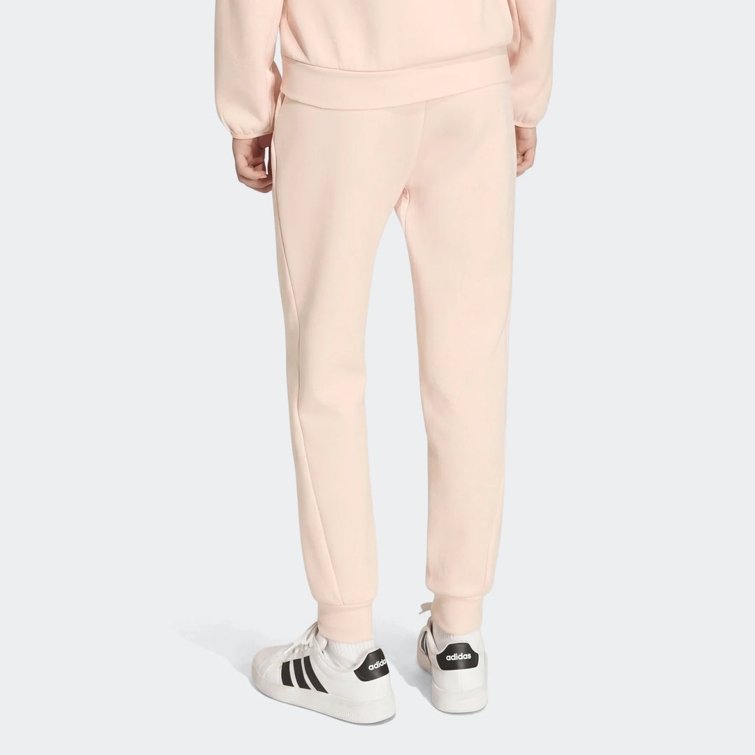 Youth Z.N.E. Track Pants in light pink, seen from the back on a model wearing white sneakers and a matching sweatshirt.