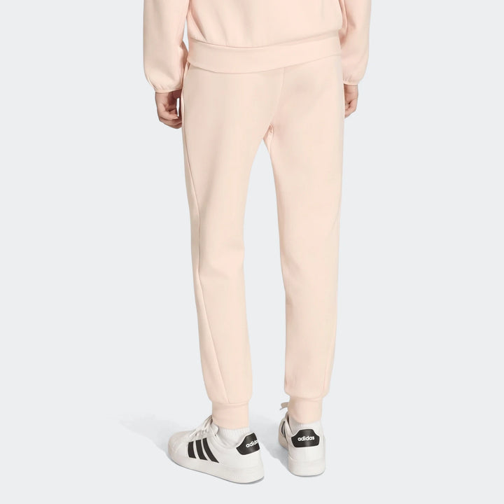 Youth Z.N.E. Track Pants in light pink, seen from the back on a model wearing white sneakers and a matching sweatshirt.