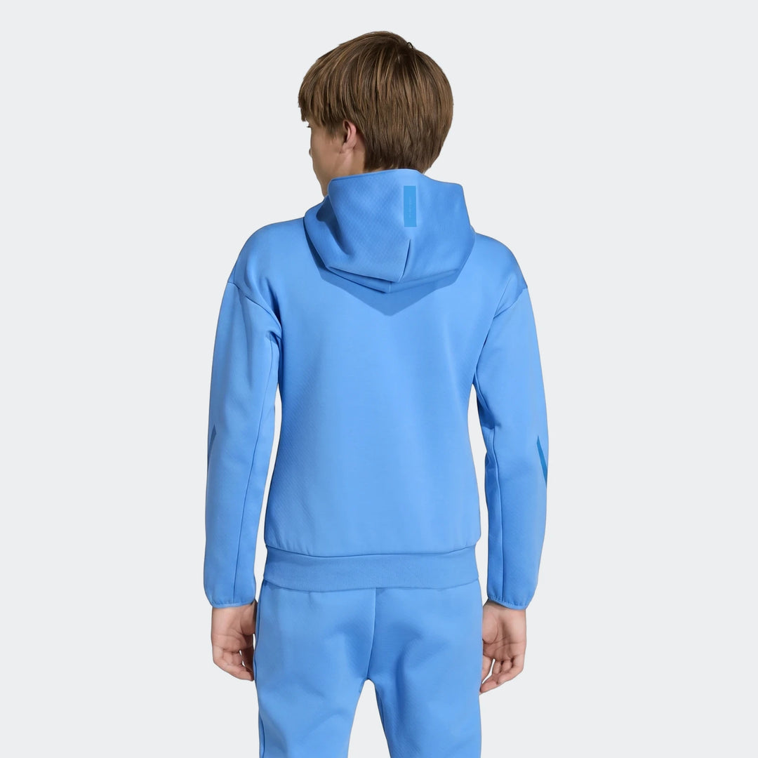 Back view of a young boy modeling a blue Youth Z.N.E. Full-Zip Hoodie with matching blue sweatpants, showcasing the design