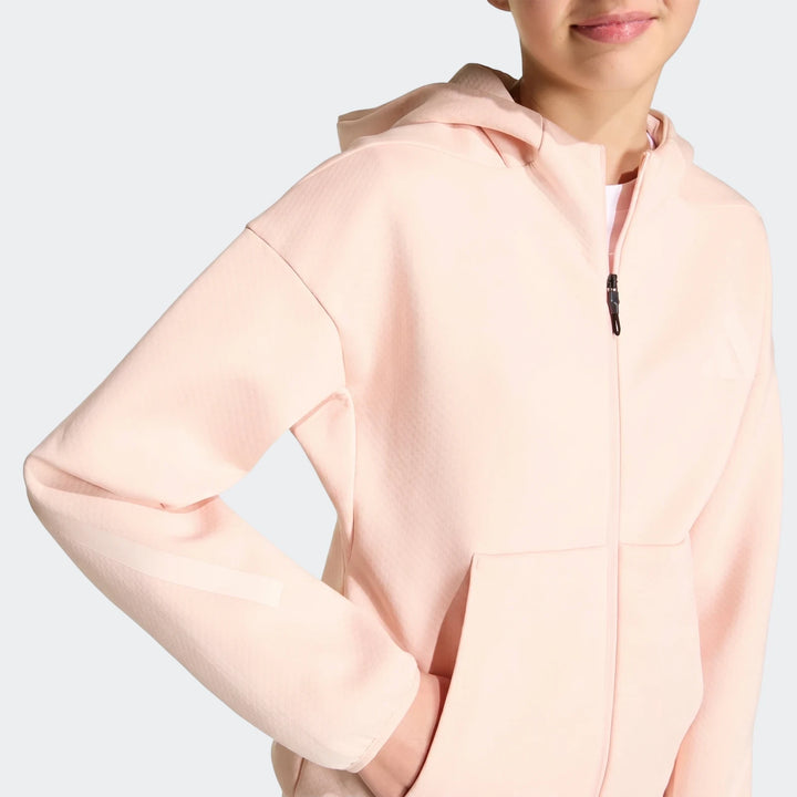 Youth Z.N.E. Full-Zip Hoodie in light pink, worn by a young person, featuring a front zipper and kangaroo pocket, close-up