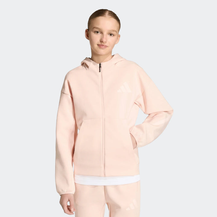 Youth Z.N.E. Full-Zip Hoodie in peach, worn by a young girl standing frontally, with hands in pockets.