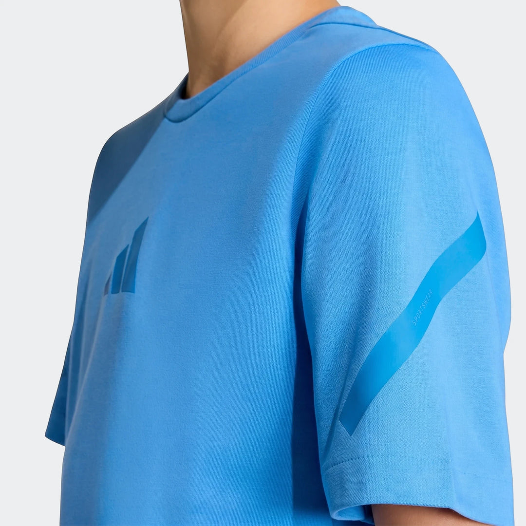 Close-up of a youth wearing a bright blue Z.N.E. T-Shirt with visible textured fabric and logo on the chest.
