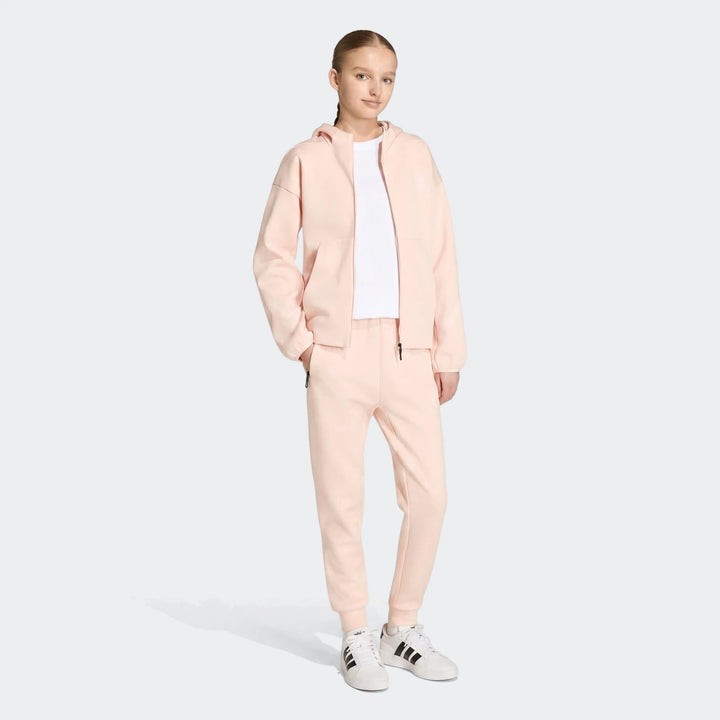 Youth Z.N.E. Track Pants in light pink, tapered jogger fit with elastic cuffs, shown in full-length front view.