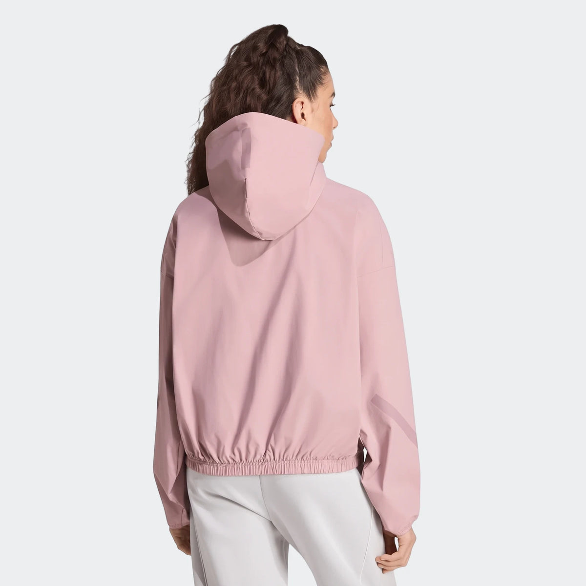 Women's pink Z.N.E. Woven Track Top, hooded, shown from the back with an elasticated hem.