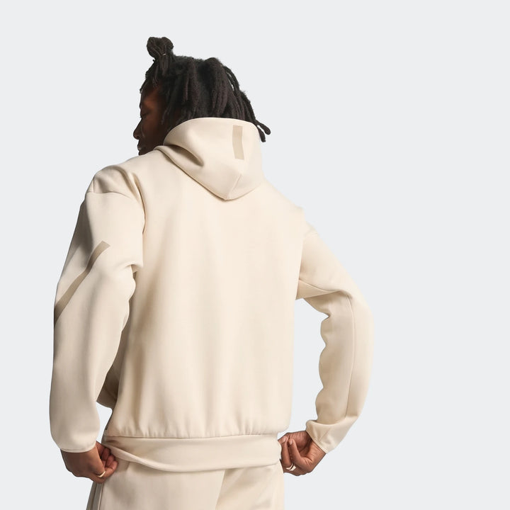 Cream Z.N.E. Full-Zip Hoodie worn by a model with dreadlocks, captured from the back. Versatile and comfortable sportswear.